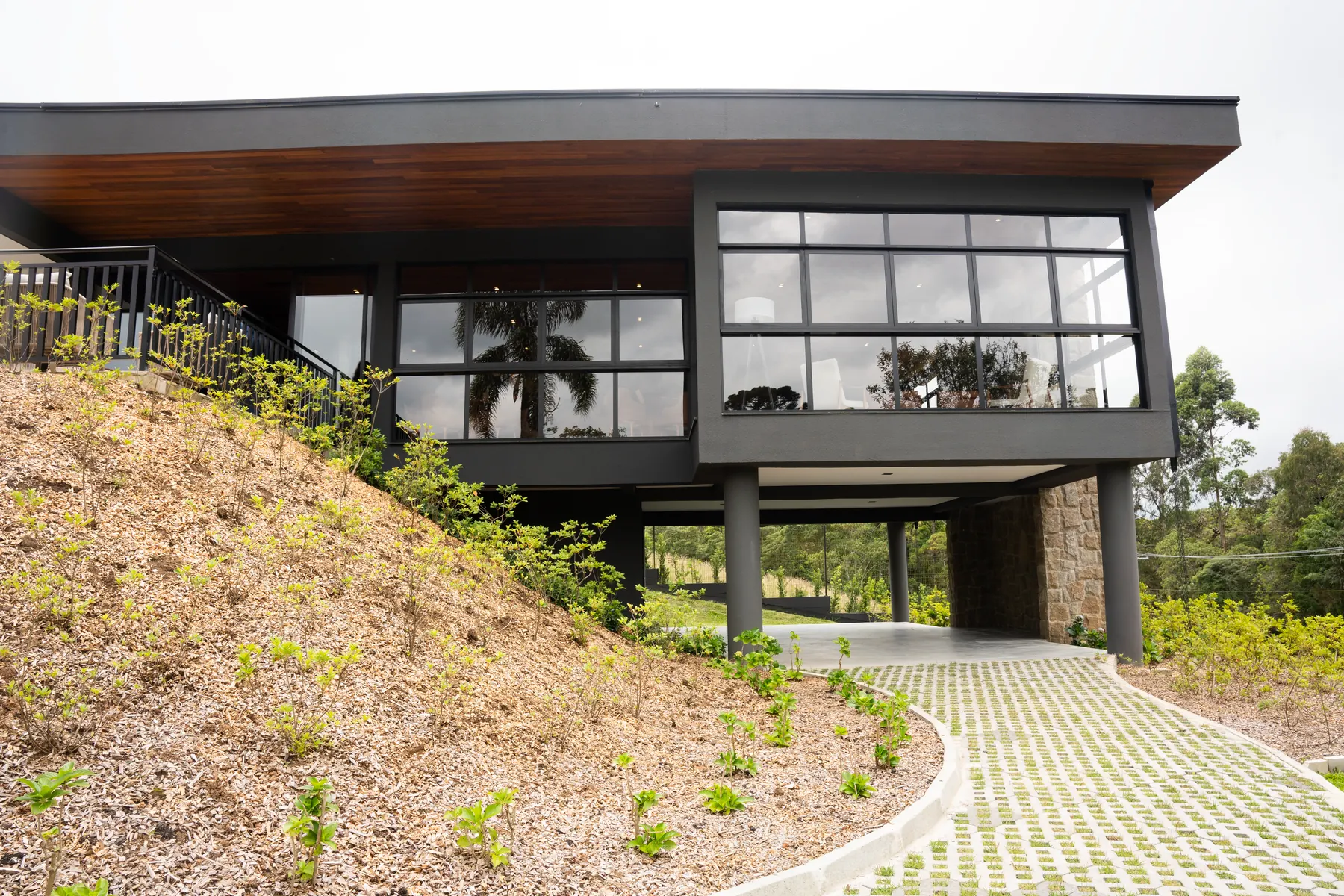 Casa sobre pilotis aproveitando o relevo