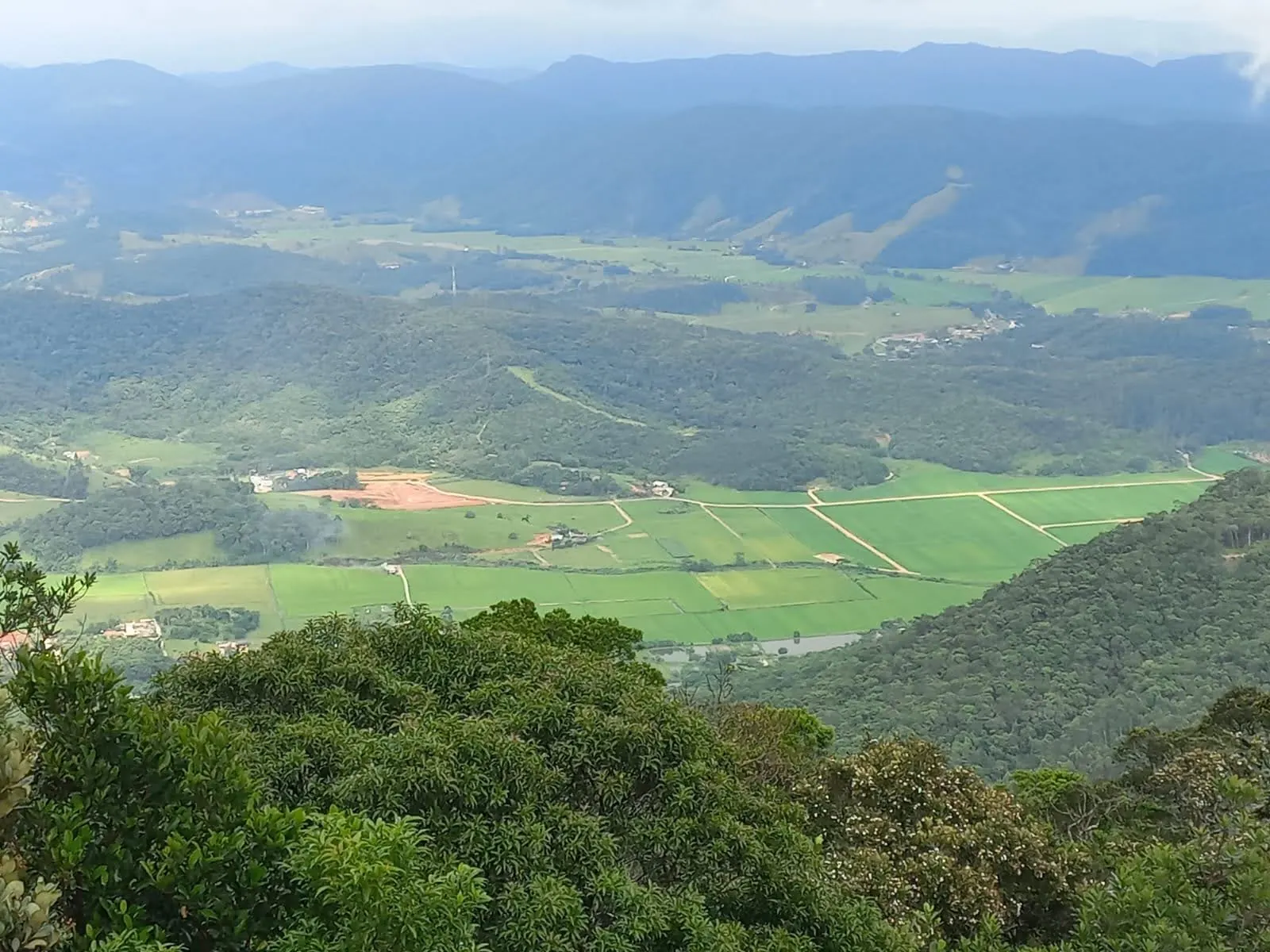 Vale de Camboriú visto do alto, com campos e morros cobertos de mata